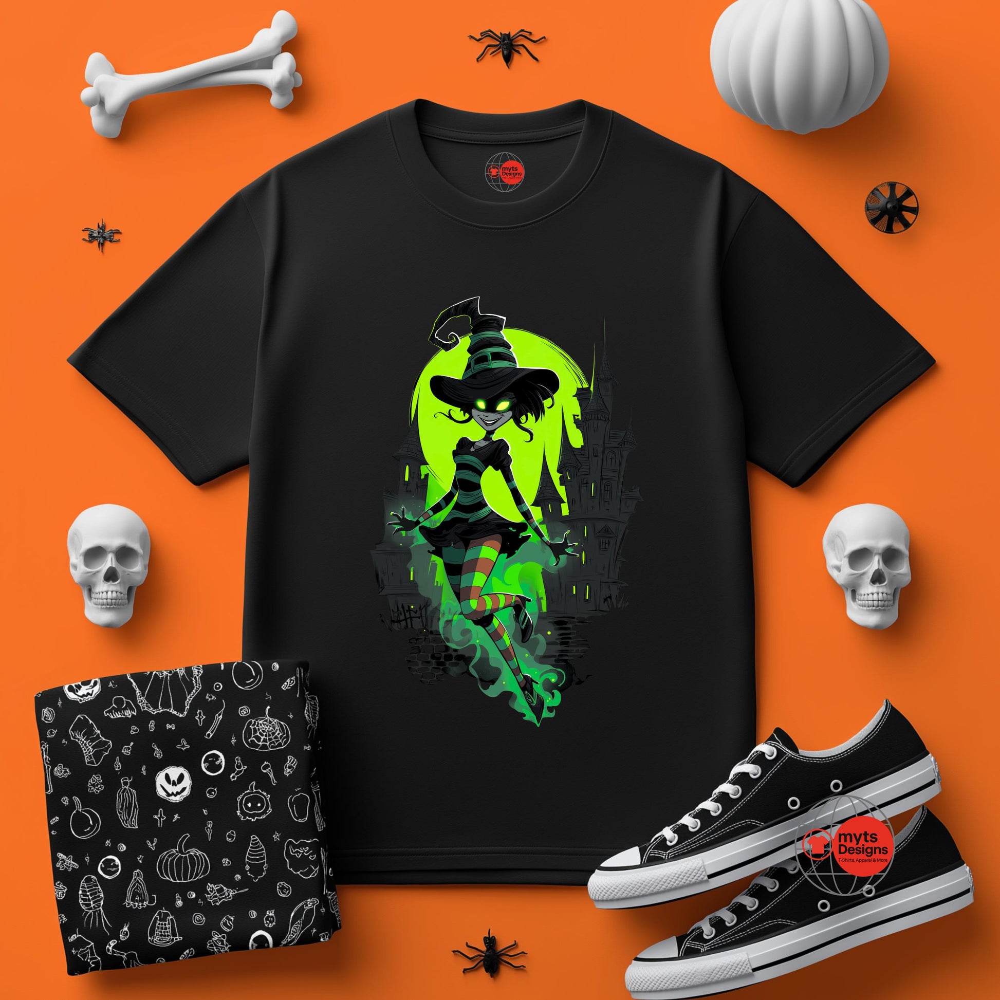 Black t-shirt with witch graphic on an orange background with Halloween-themed accessories.