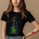 Person wearing a black t-shirt with a green witch graphic on a beige background