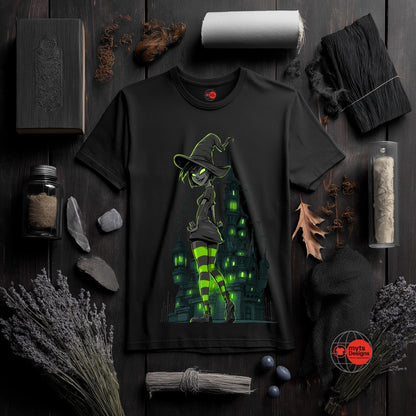 Black t-shirt with witch graphic on a dark wooden surface with Halloween-themed decor.