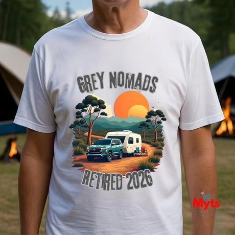 A man wearing a white graphic t-shirt with a retro-style camping scene print that reads 'GREY NOMADS RETIRED 2026'. The background is a blurred outdoor campsite with tents and fire pits.