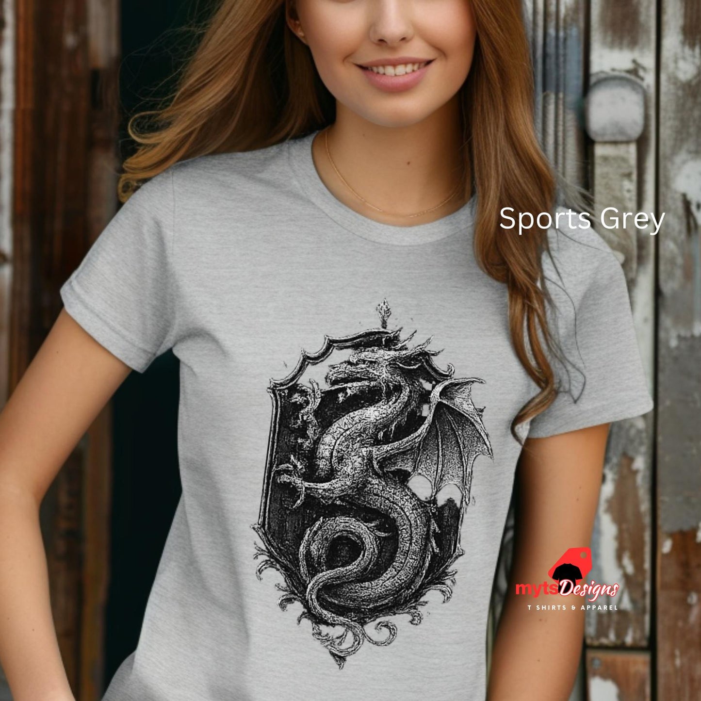 Person wearing a gray t-shirt with a dragon design, standing against a rustic wooden background.