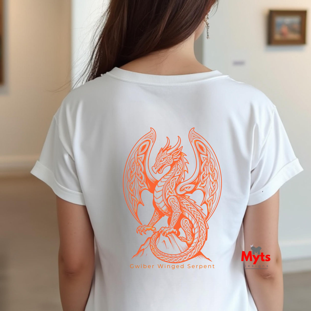 A woman viewed from behind wearing a white short-sleeve T-shirt with a large orange line-art dragon graphic on the back and small text reading 'Gwiber Winged Serpent' beneath it.