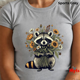 A light grey short-sleeve t-shirt featuring a detailed graphic of a raccoon holding a bouquet of wildflowers, worn by a model. The text 'Sports Grey' is visible in the top right corner, and a 'Myts' brand logo is in the bottom right.