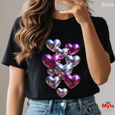 Woman wearing black t-shirt with iridescent holographic heart balloon graphic in shiny pink, purple and blue tones, taking a mirror selfie