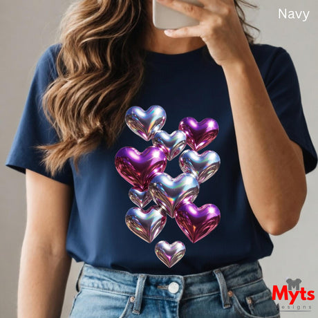 Person wearing a navy t-shirt with colorful heart design, taking a selfie.