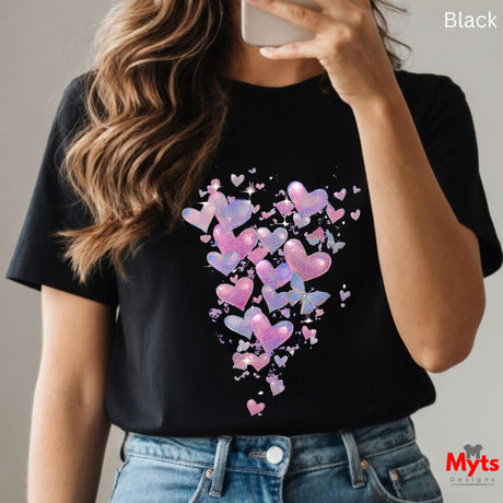Woman wearing black t-shirt with glitter hearts and butterflies graphic featuring sparkling pink, purple, and blue hearts with delicate butterflies