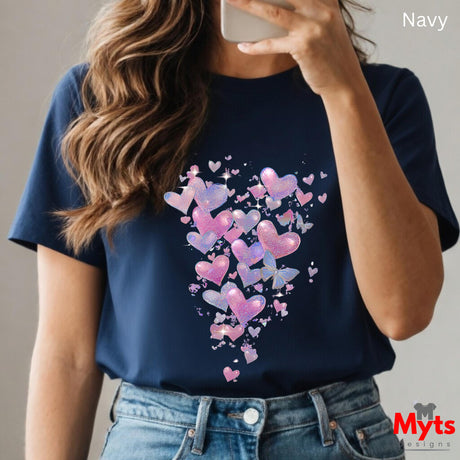 Person wearing a navy t-shirt with colorful heart design, taking a selfie.