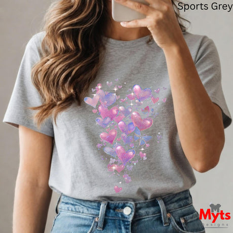 Person wearing a gray t-shirt with colorful heart design, taking a selfie.