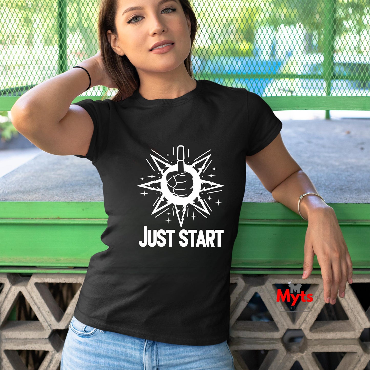 Woman wearing a black t-shirt with 'Just Start' design and text, standing outdoors.