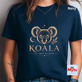 A navy blue short-sleeve t-shirt with a gold koala graphic and the text 'KOALA MY TREE, MY HOME' on the front. The image shows a person wearing the shirt, with 'Navy' text in the top right and a 'Myts Designs' logo in the bottom right corner.
