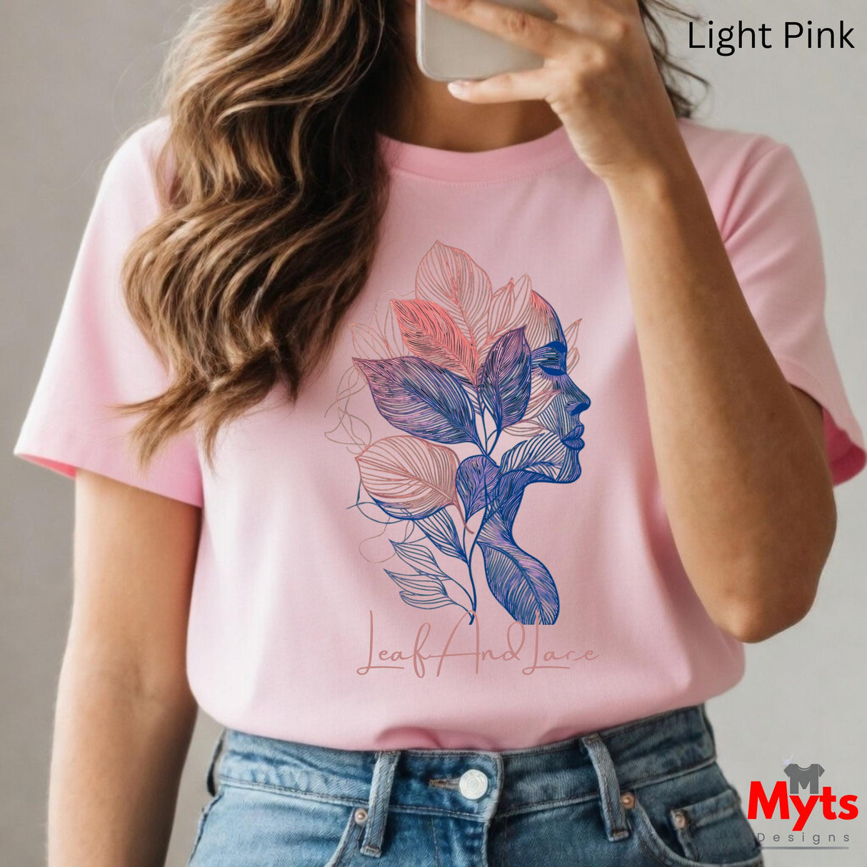 Person wearing a pink t-shirt with a colorful leaf design and 'Myts Designs' branding.