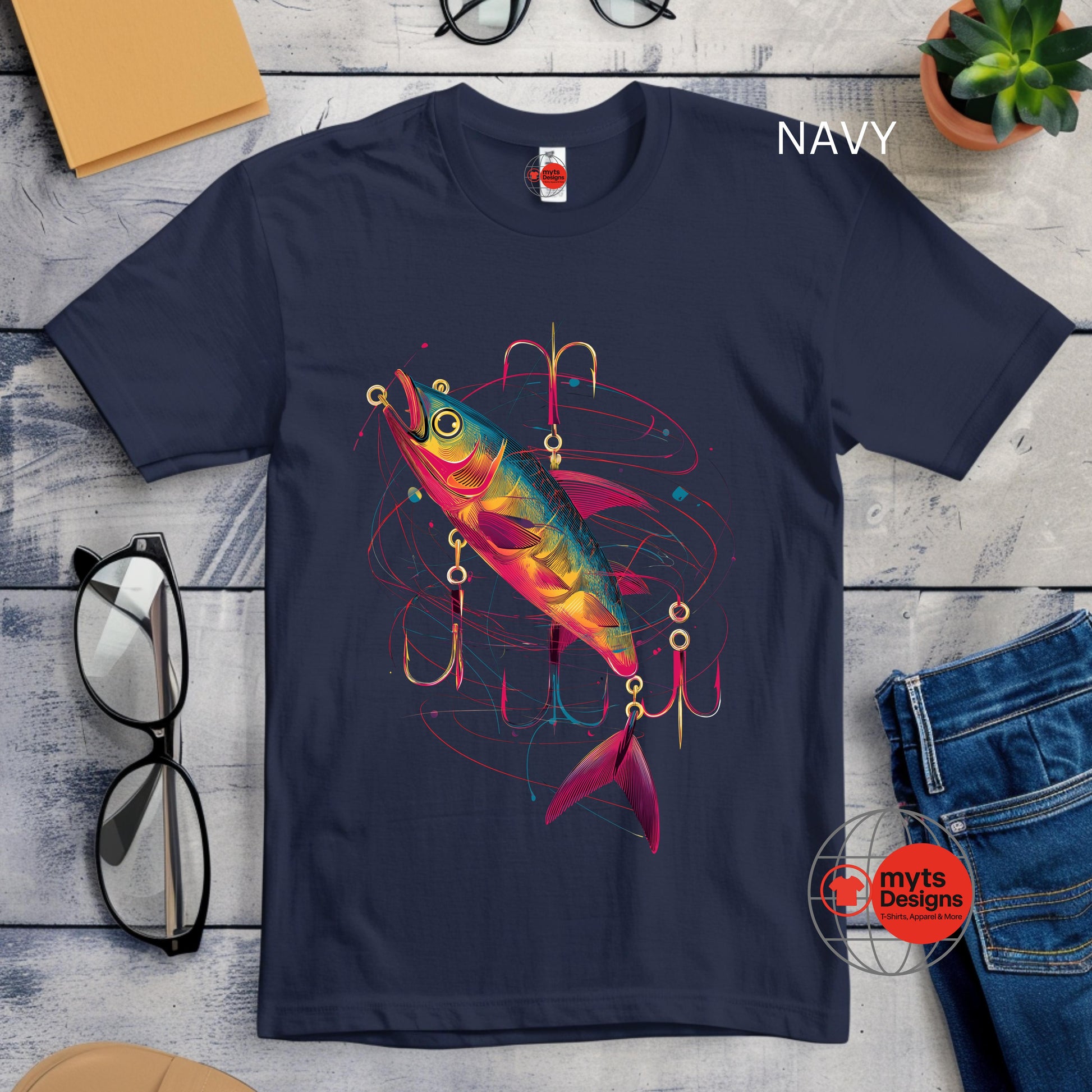 Navy blue t-shirt with a colorful fish and lure graphic on a wooden surface.