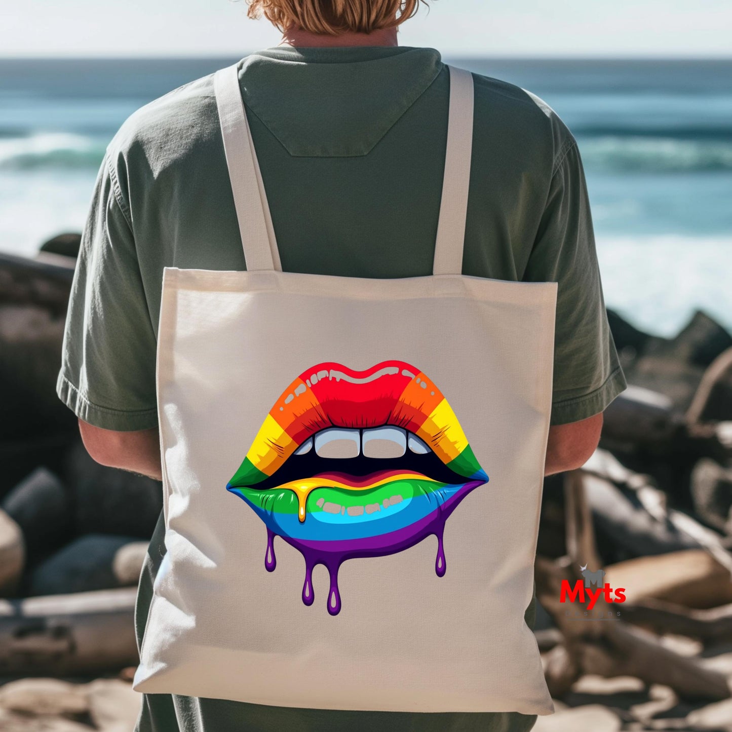 Person wearing a tote bag with rainbow lips design by the ocean.
