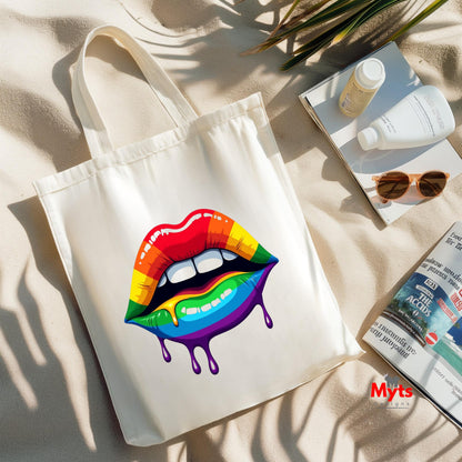 Tote bag with rainbow lips design on a beige surface with magazines and sunglasses.