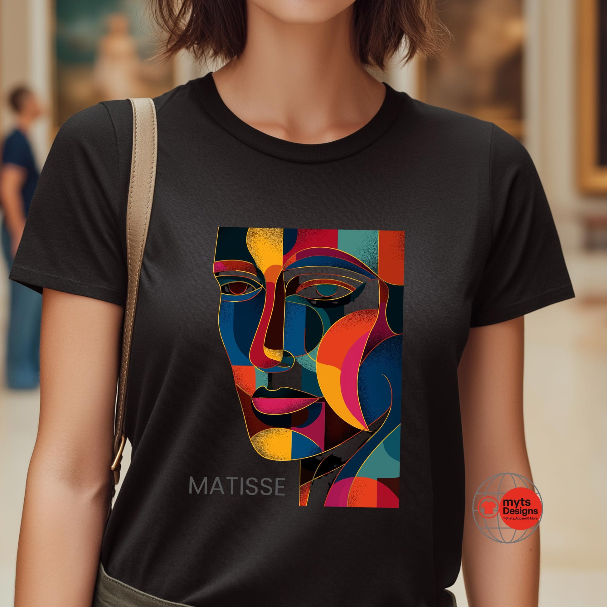 Person wearing a black t-shirt with a colorful abstract design and 'Matisse' text, standing in an indoor setting.