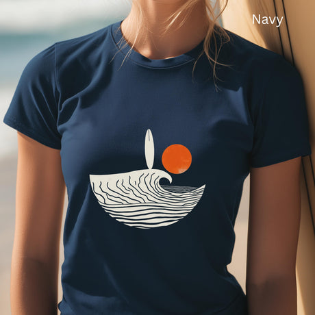 Navy t-shirt with a wave and sun design worn by a person on a beach.