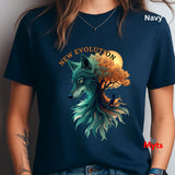 A person wearing a navy blue graphic T-shirt. The shirt features a stylized teal wolf head merging with an autumn tree and orange full moon, with the words 'NEW EVOLUTION' above.
