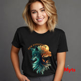 A smiling blonde woman wearing a black graphic T-shirt with a stylized wolf and tree design in teal, orange, and yellow, plus the words 'NEW EVOLUTION' across the chest, against a plain gray studio background.