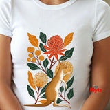 A white short-sleeve crewneck t-shirt featuring a colorful graphic print of a kangaroo surrounded by orange flowers and green leaves, worn by a model.