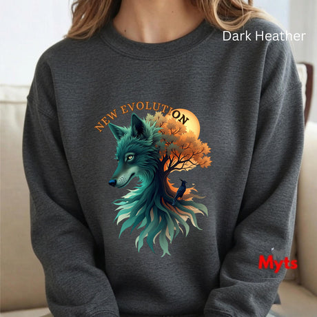A person wearing a dark heather gray sweatshirt with a large graphic of a teal wolf merging into an autumn tree with an orange sun and the words 'NEW EVOLUTION'. The sweatshirt has 'Dark Heather' text at the top right and a red 'Myts' logo at the bottom right.