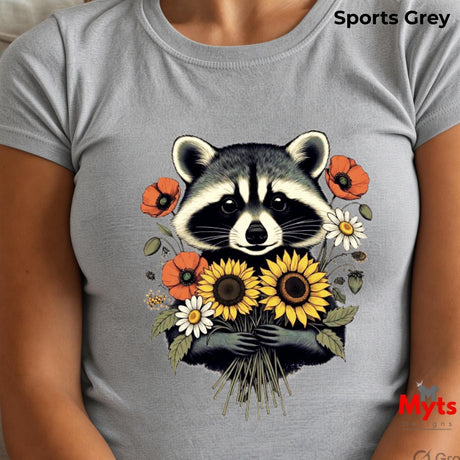 A person wearing a light gray t-shirt with a detailed graphic of a raccoon holding a bouquet of sunflowers, daisies, and poppies. The text 'Sports Grey' is visible in the top right corner, and a 'Myts' brand logo is in the bottom right corner.