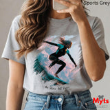 Person wearing a t-shirt with a graphic design of a person on a surfboard, holding a phone.