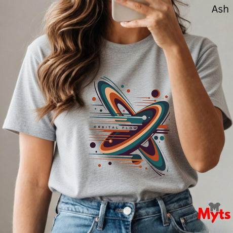 Person wearing a Ash t-shirt with a colorful graphic design, holding a phone.