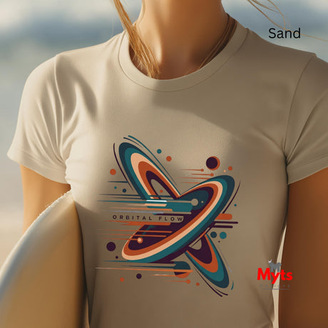 Person wearing a Sand t-shirt with a colorful 'Orbital Flow' design, standing on sand with a blurred background.