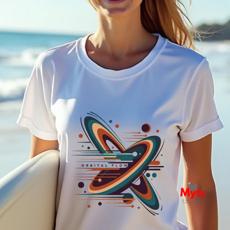 Person wearing a white t-shirt with a colorful graphic design, standing by the water.