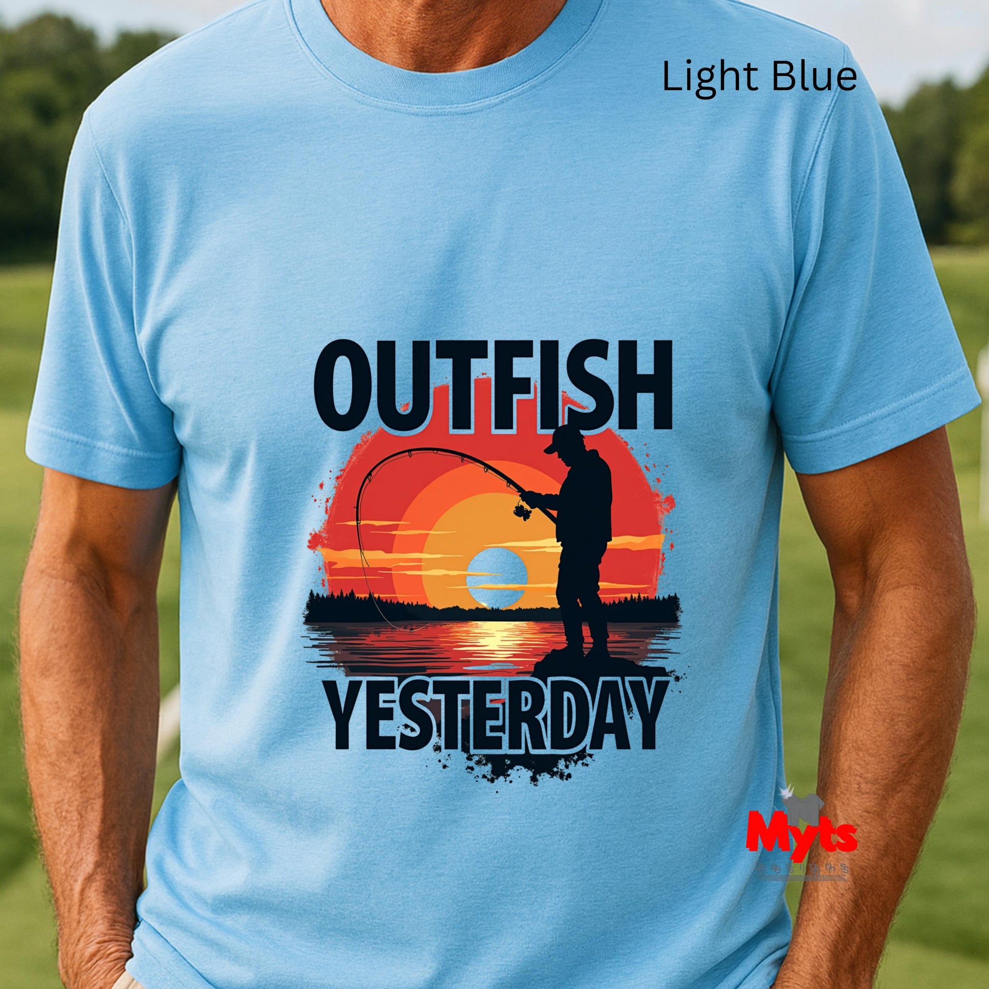 Light blue t-shirt with a fishing graphic and text 'Outfish Yesterday' on a grassy background.
