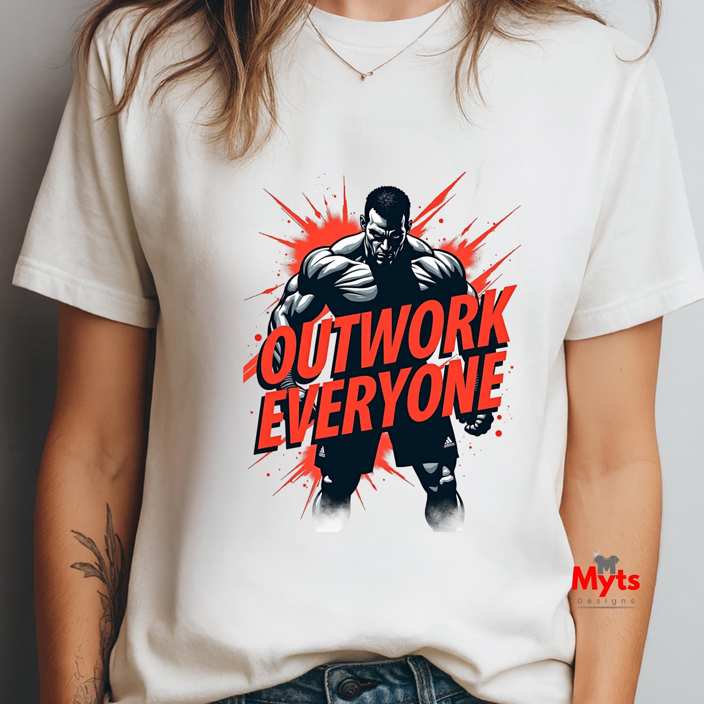 White t-shirt with a graphic of a muscular figure and 'Outwork Everyone' text, worn by a person.