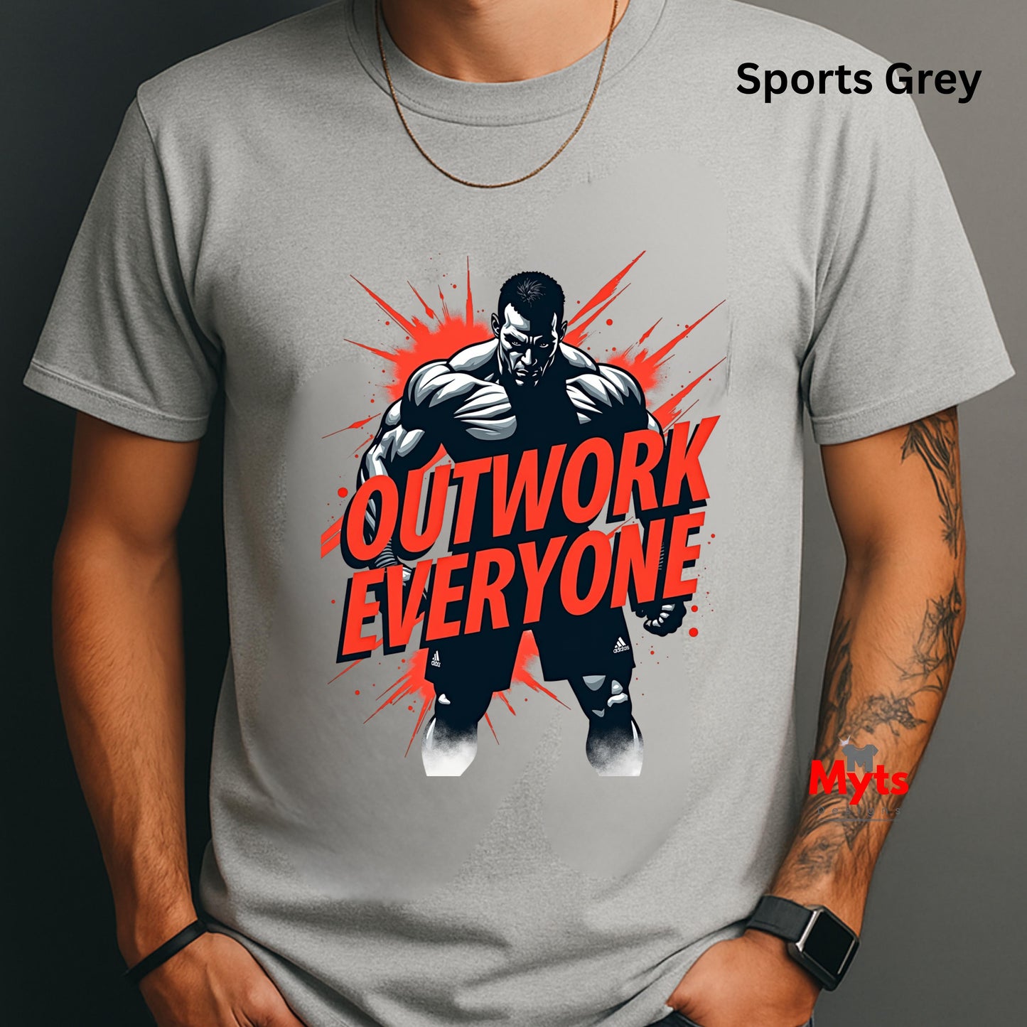 Gray t-shirt with a graphic of a muscular man and 'Outwork Everyone' text, worn by a person.