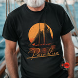 Person wearing a black t-shirt with a sailboat design and 'Paradise' text on a boat.
