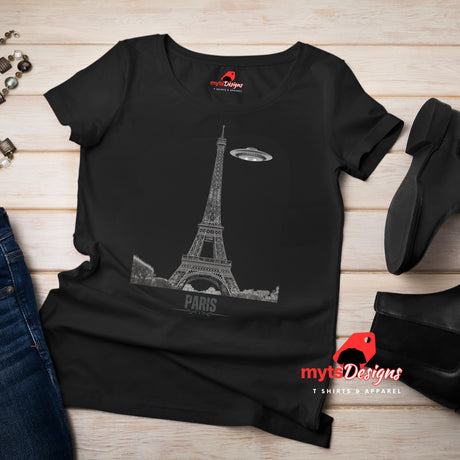 Flat lay view of a black soft casual tee featuring a whimsical graphic of the Eiffel Tower with a retro‑style spaceship orbiting it, printed on ultra‑soft Gildan 64000 cotton.