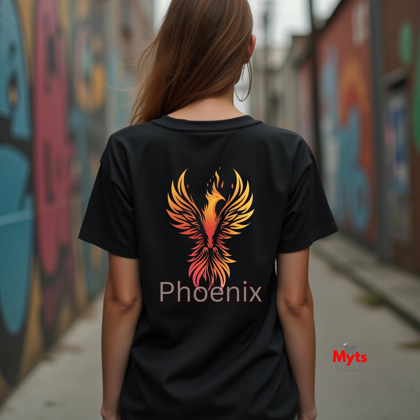Person wearing a black t-shirt with a phoenix design and 'Phoenix' text, standing in front of graffiti walls.