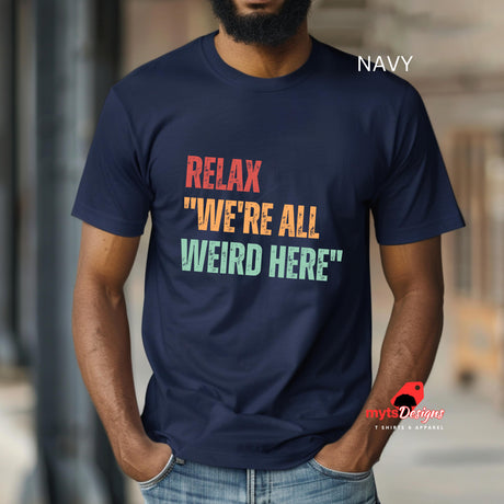 A man wearing a navy Retro-style casual tee featuring bold distressed vintage typography reading “Relax — We’re All Weird Here,” printed on ultra-soft Gildan 64000 cotton.

