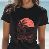 Black t-shirt with a pink palm tree and sunset design on a blurred beach background