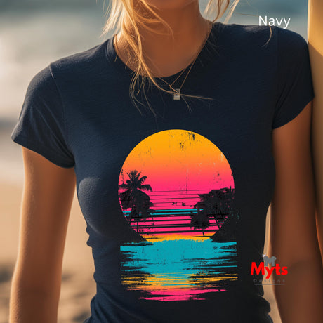 Person wearing a navy t-shirt with a colorful sunset design on a beach.