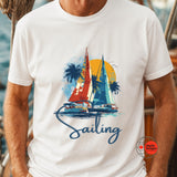 White t-shirt with sailboat graphic and 'Sailing' text worn by a person.