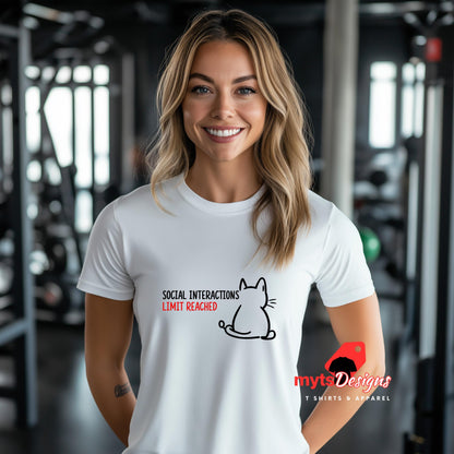 “White T-shirt worn by a young woman with a minimal line art cat and text reading ‘Social Interactions Limit Reached’ in bold black and red font, humorous introvert design from MytsDesigns.com”