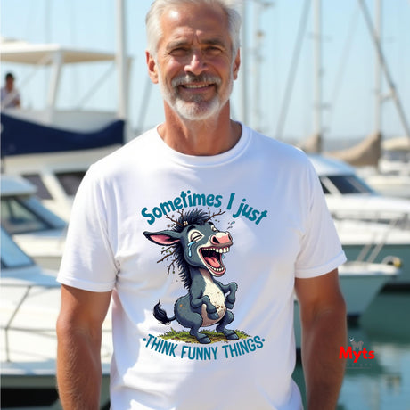 Man wearing a white t-shirt with a cartoon donkey graphic and text at a marina.