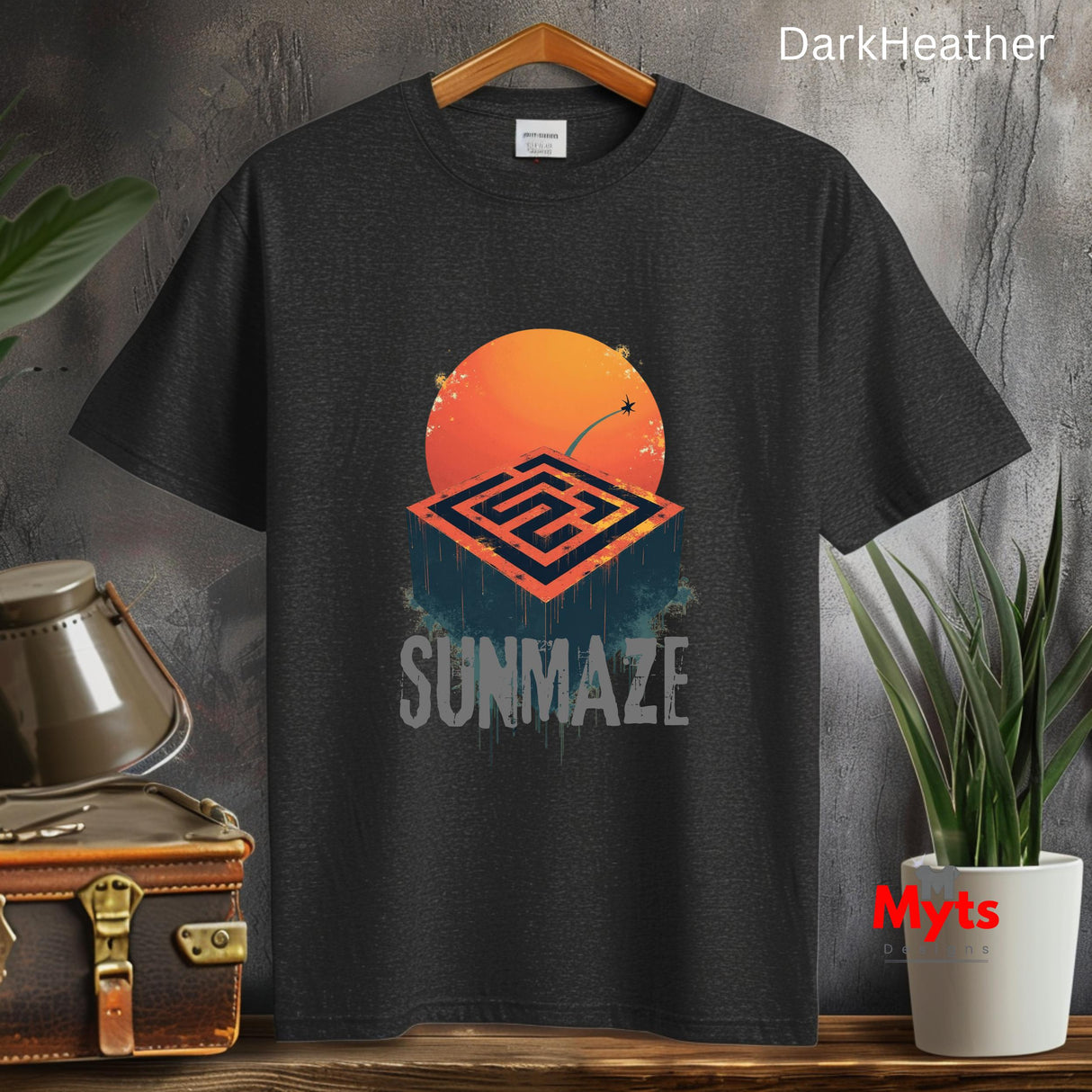 Dark Heather t-shirt with 'Summaze' design on a wooden surface with plants and a suitcase.