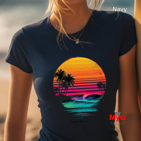 Person wearing a navy t-shirt with a colorful sunset and palm tree design, standing by a beach.