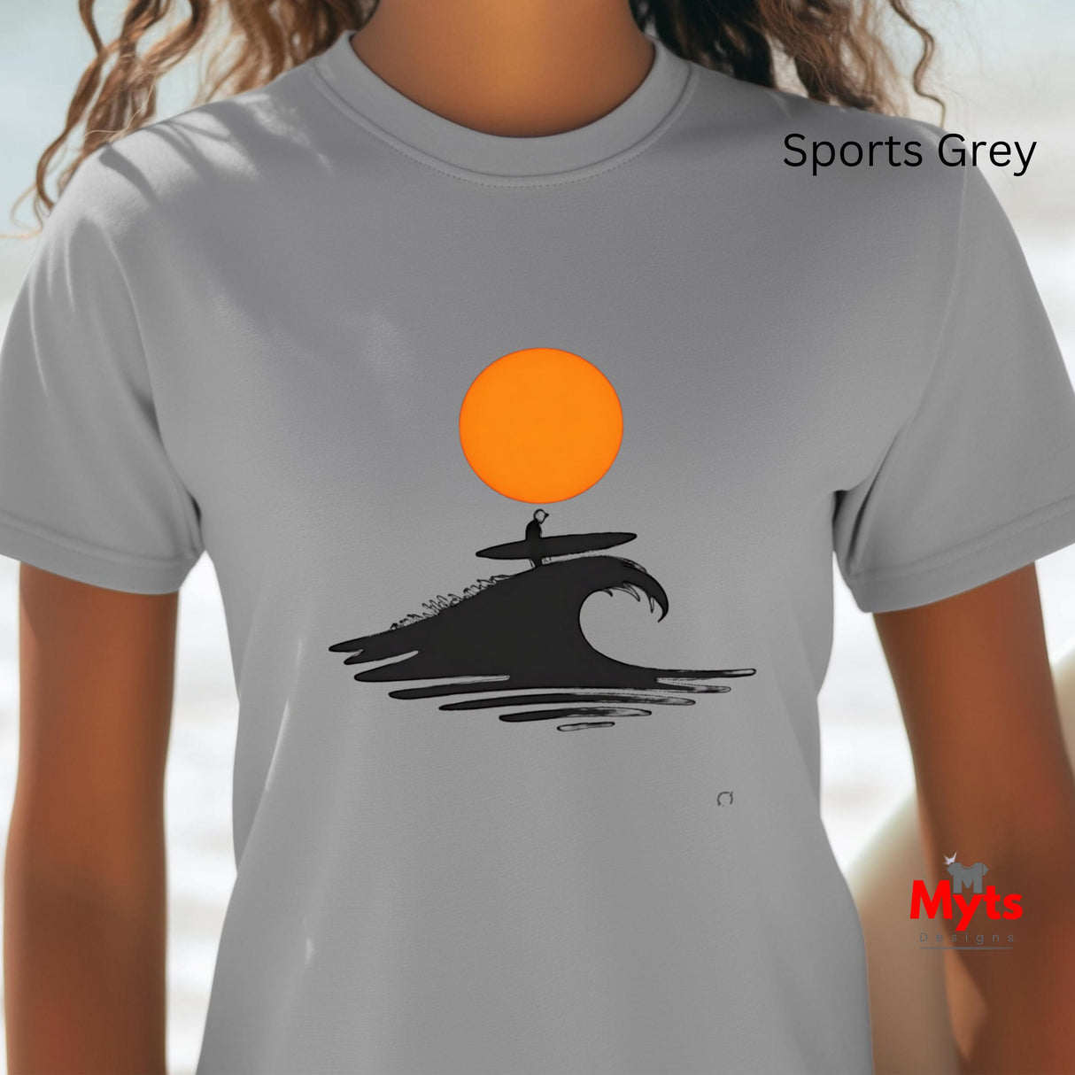 Sports Gray t-shirt with a graphic design of a surfer on a wave and an orange sun, worn by a person.