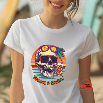 T-shirt featuring a retro-style skull with sunglasses, palm tree, tropical cocktail, and sunset background. "Sunset & Skulls" printed below. Worn by smiling woman at the beach.
