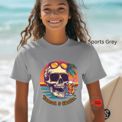Person wearing a gray t-shirt with a skull graphic and sunglasses on a beach.