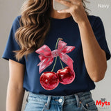 Person wearing a navy t-shirt with cherry and bow design, taking a selfie.