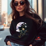 Woman wearing a black sweatshirt with a witch design and moon on a city street.