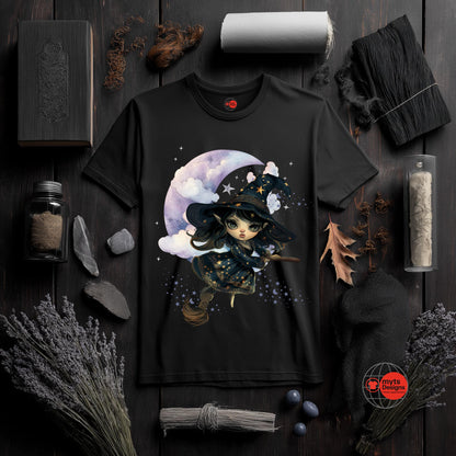 Black t-shirt with a witch design on a dark wooden surface with decorative items.