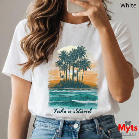 Person wearing a white t-shirt with a tropical island graphic and 'Take a Stand' text, holding a phone.